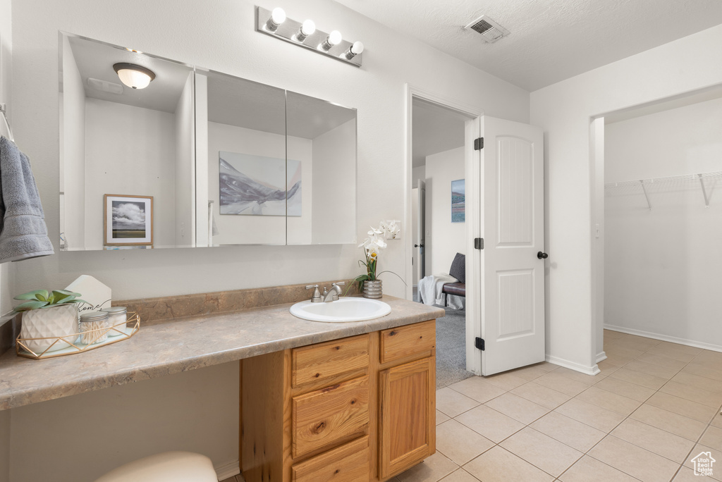 Bathroom with vanity, tile patterned floors, and baseboards