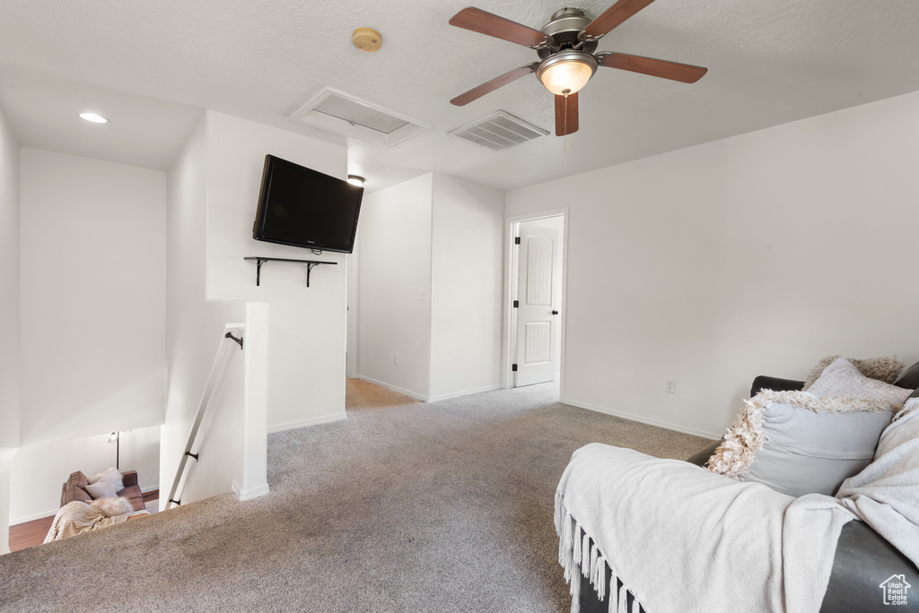 Sitting room with an upstairs landing, attic access, carpet floors, baseboards, and ceiling fan