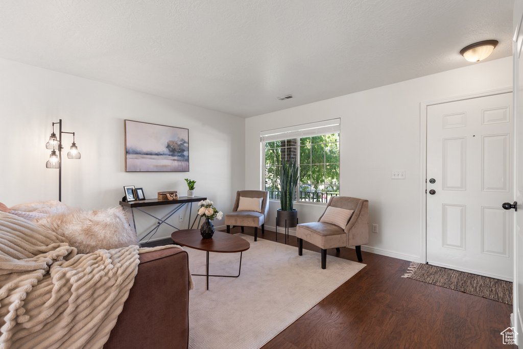 Living area featuring dark wood-style floors and baseboards