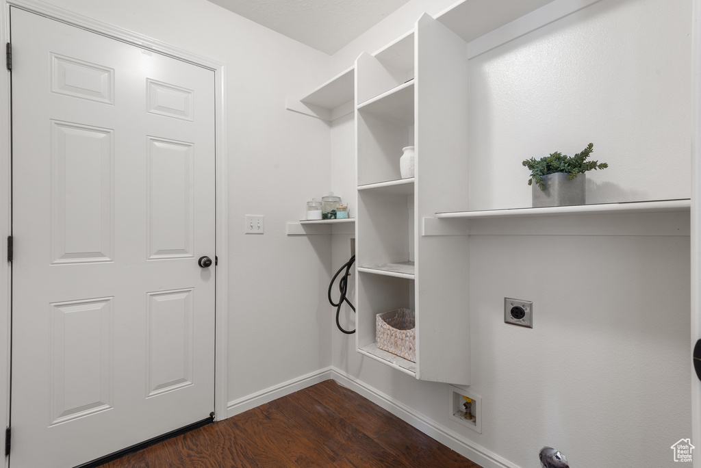 Washroom with hookup for an electric dryer, dark wood-style flooring, and baseboards
