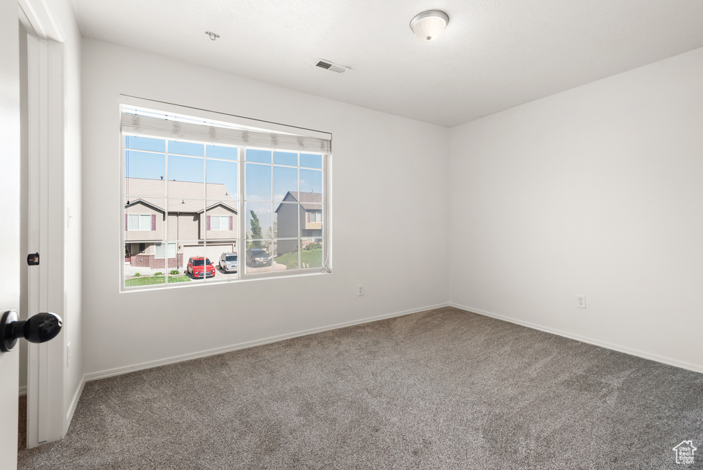 Carpeted empty room featuring baseboards