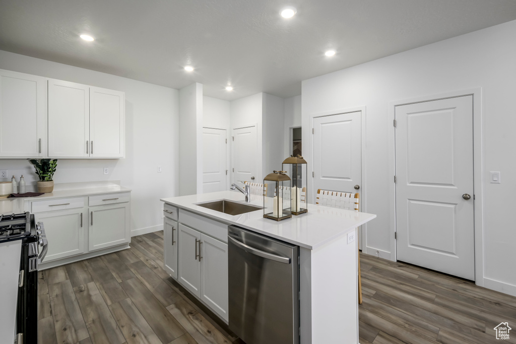 Kitchen featuring stainless steel appliances, a sink, dark wood finished floors, recessed lighting, and white cabinetry