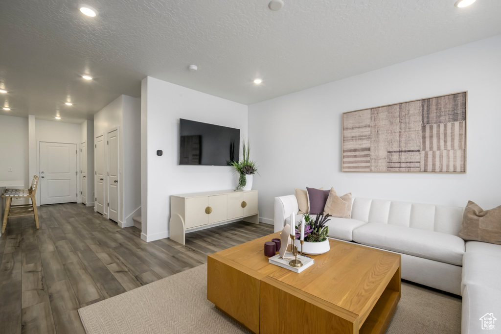 Living room with recessed lighting, dark wood-type flooring, and baseboards