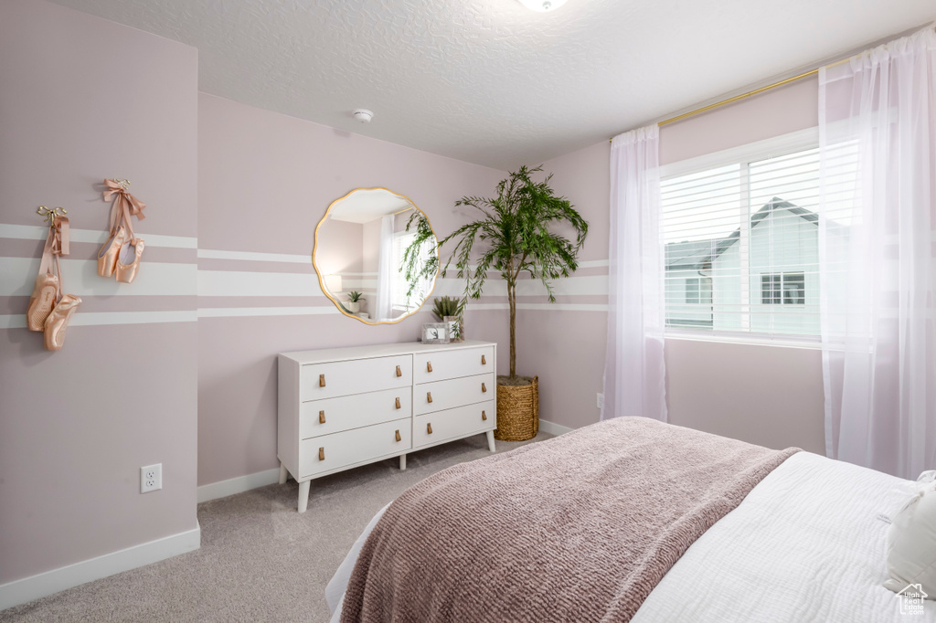 Bedroom featuring carpet floors, a textured ceiling, and baseboards