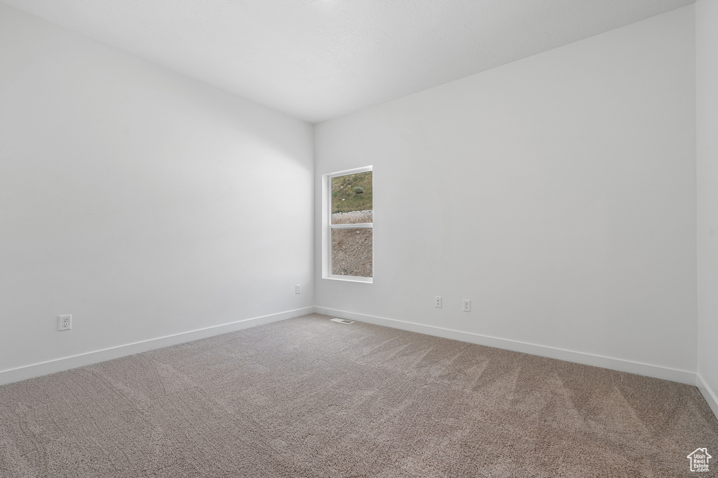 Carpeted empty room featuring baseboards