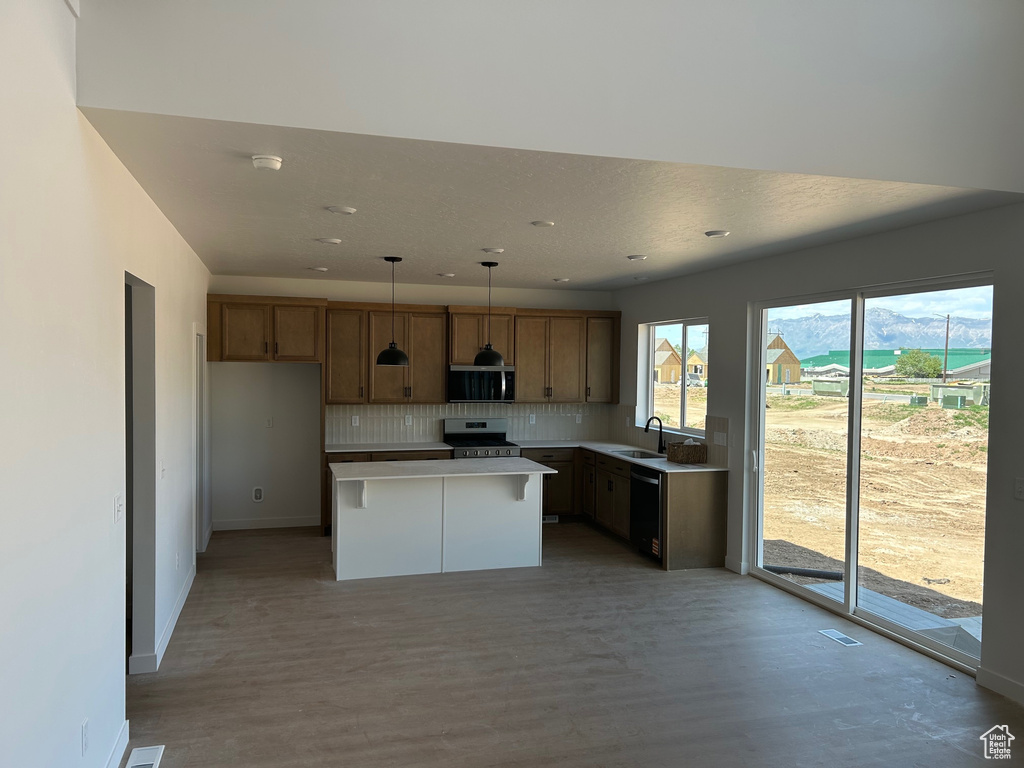 Kitchen featuring stainless steel electric range, a sink, decorative backsplash, light wood-type flooring, and recessed lighting