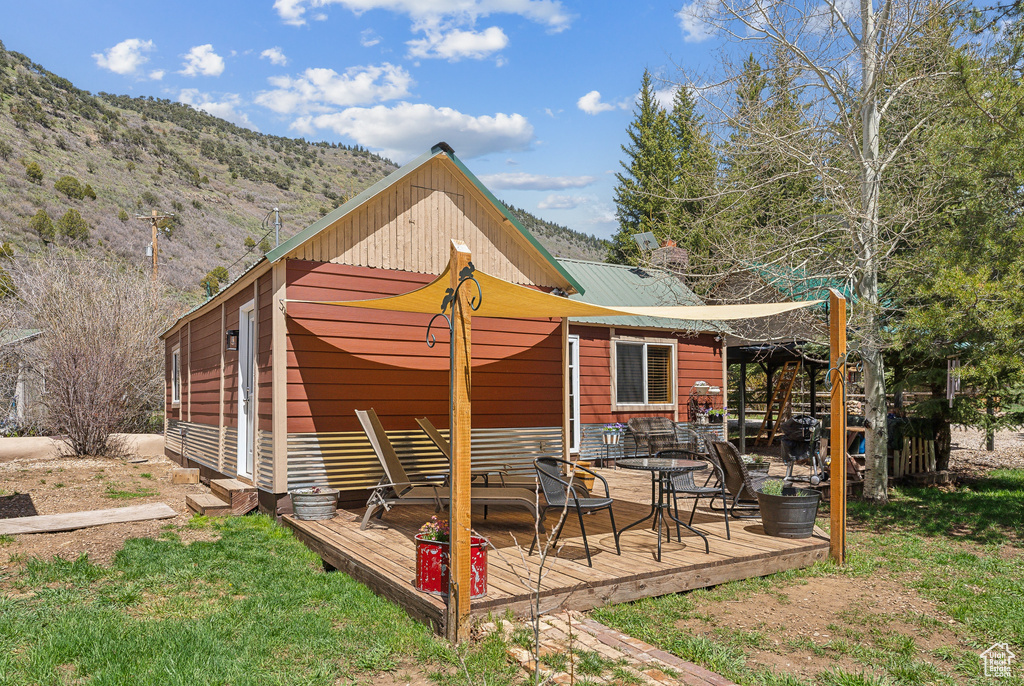 View of home's exterior with a deck with mountain view and metal roof