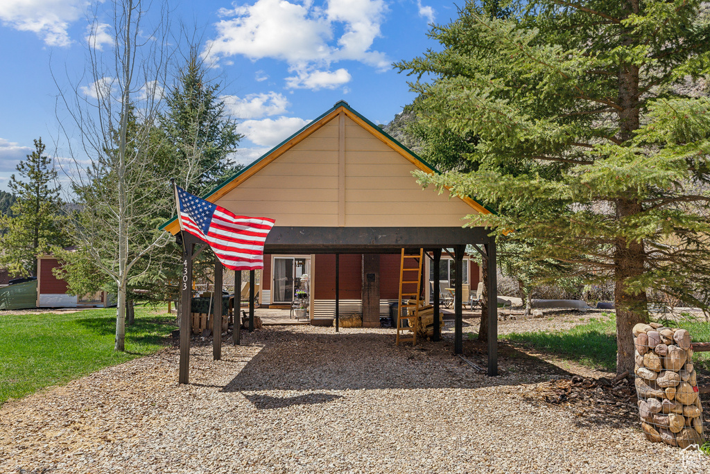 Back of house featuring driveway and a detached carport