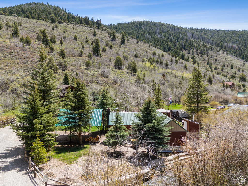 View from above of property featuring a heavily wooded area and a mountainous background