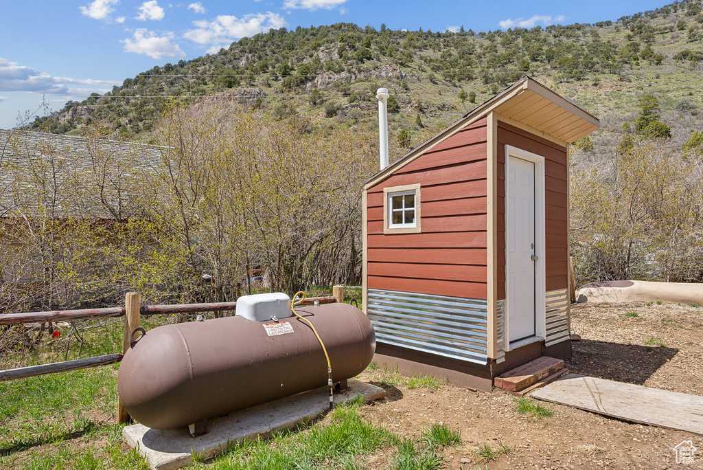 View of shed featuring a mountain view, entry steps, and fence
