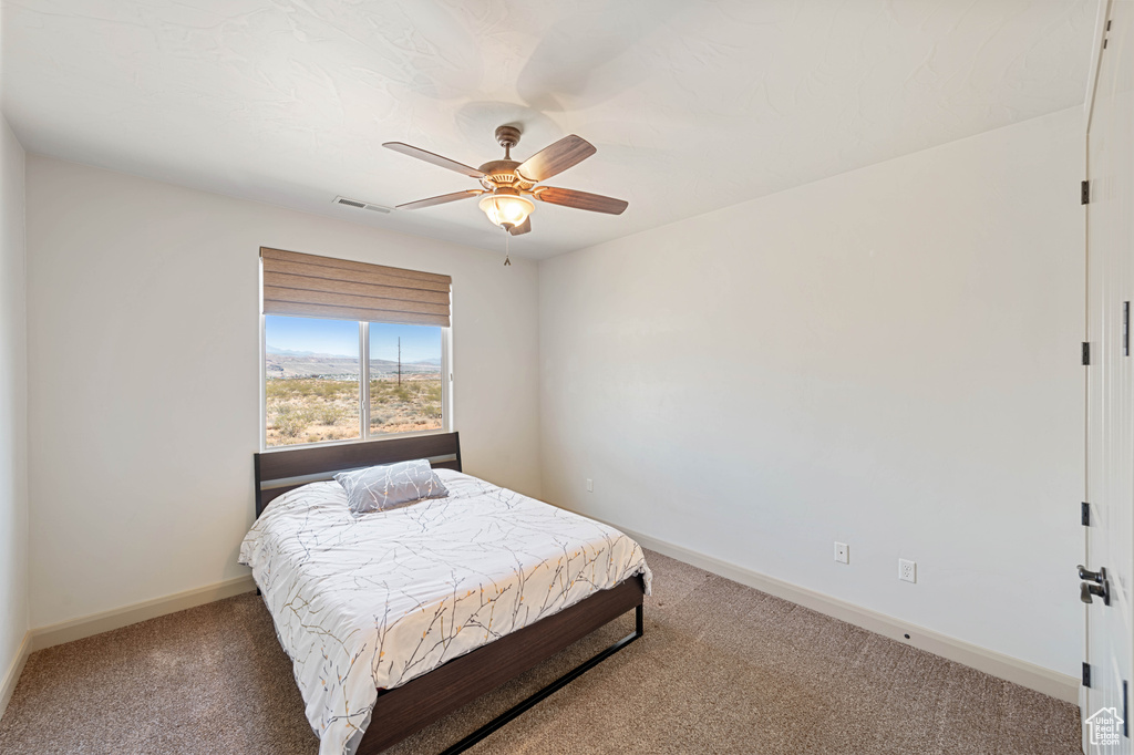 Bedroom featuring carpet floors, baseboards, and a ceiling fan