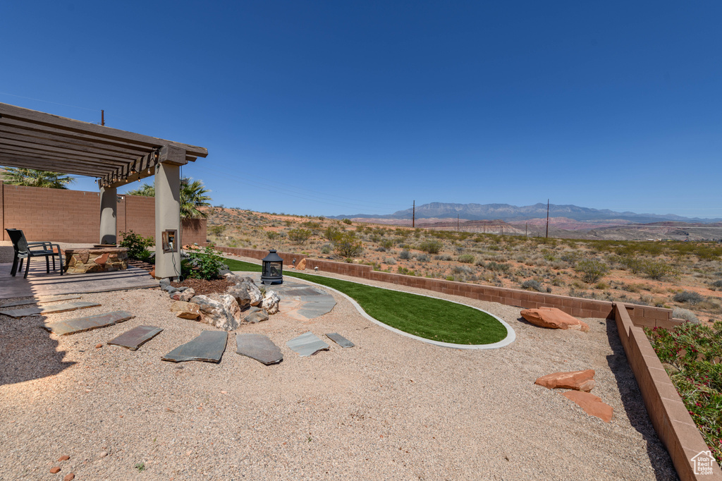 View of yard with a mountain view, a pergola, a patio, and fence