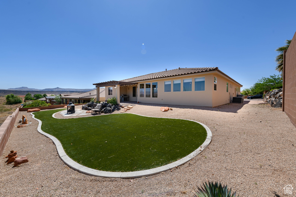 Rear view of property with a patio area, a pergola, a tile roof, stucco siding, and a mountain view