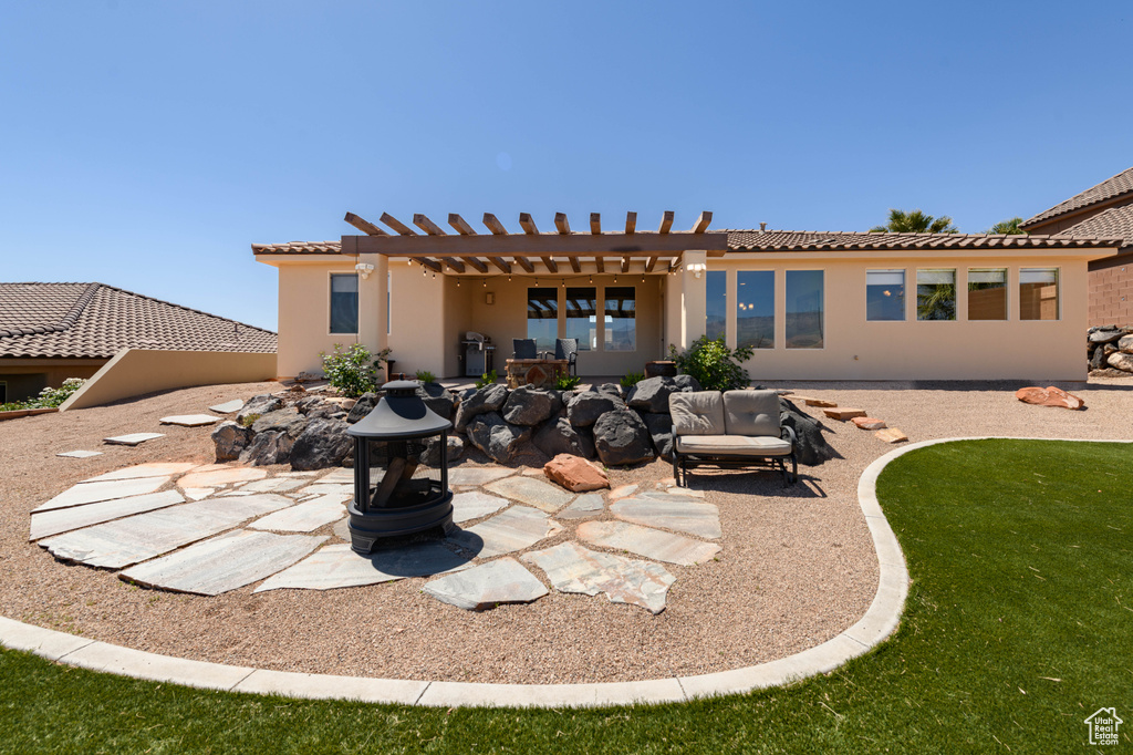 Rear view of house featuring a tile roof, a pergola, a patio area, and stucco siding