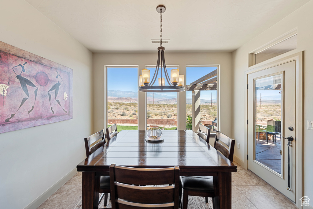 Dining area with a chandelier, baseboards, and a mountain view