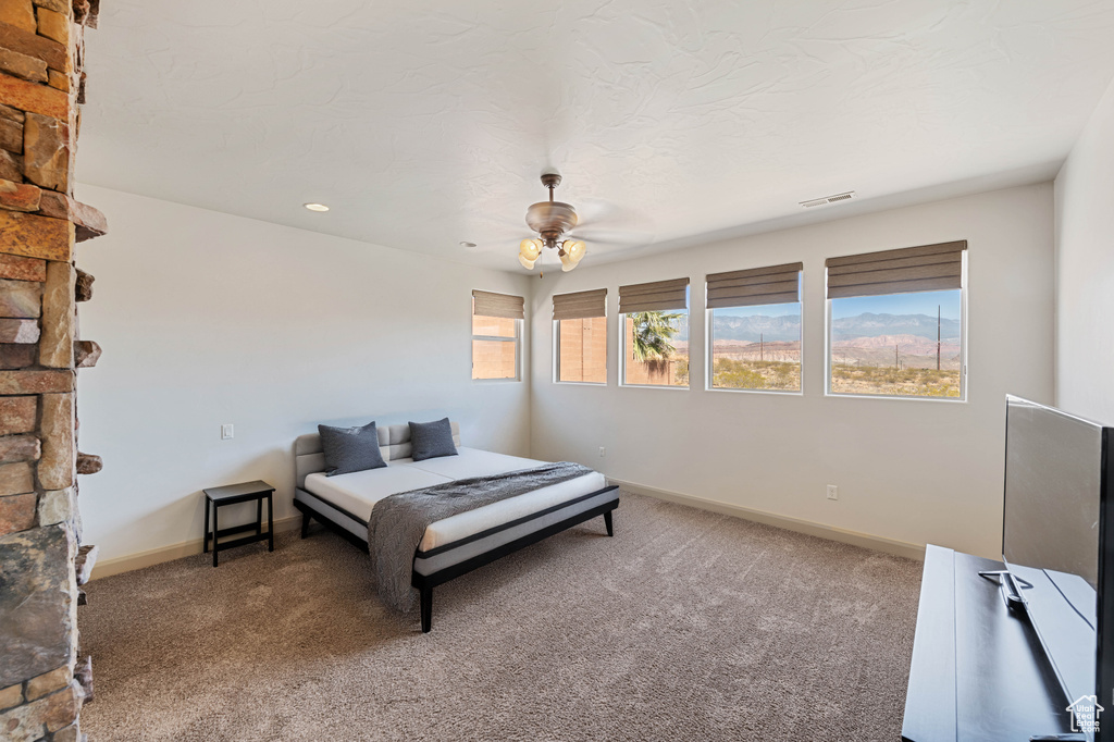 Carpeted bedroom with baseboards and a ceiling fan