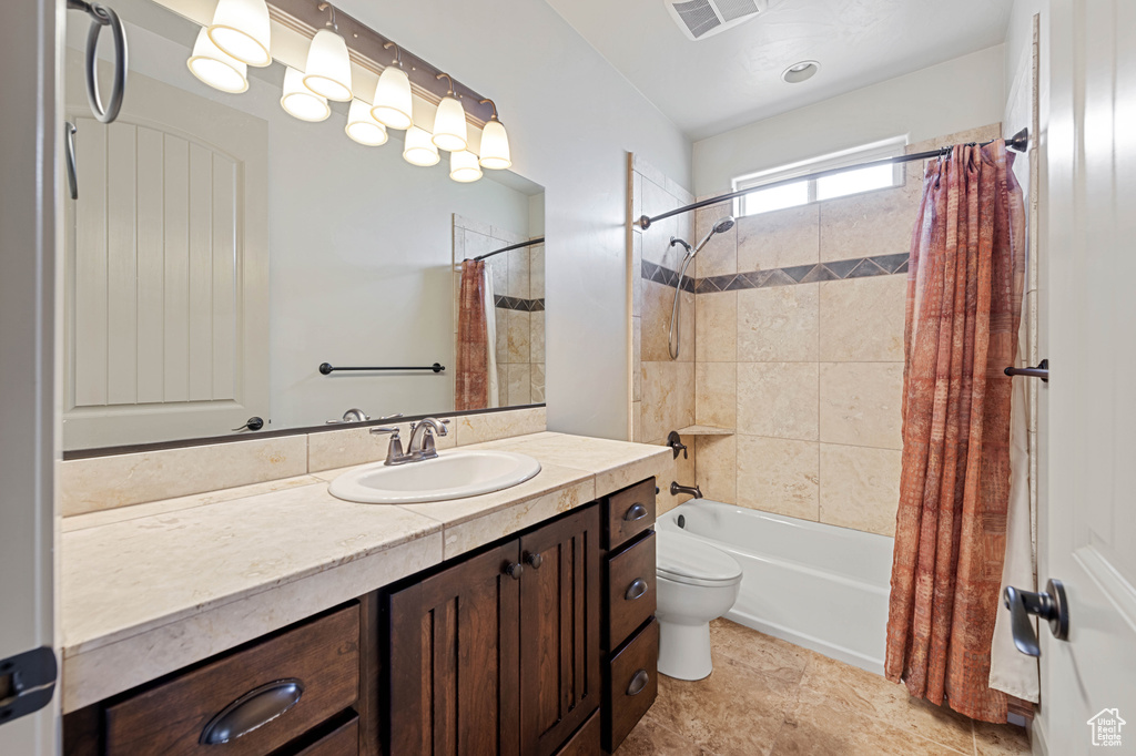 Bathroom with shower / bathtub combination with curtain, toilet, and vanity