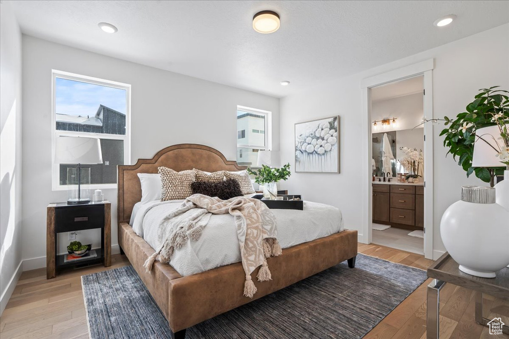 Bedroom featuring light wood-style floors, ensuite bathroom, recessed lighting, and baseboards
