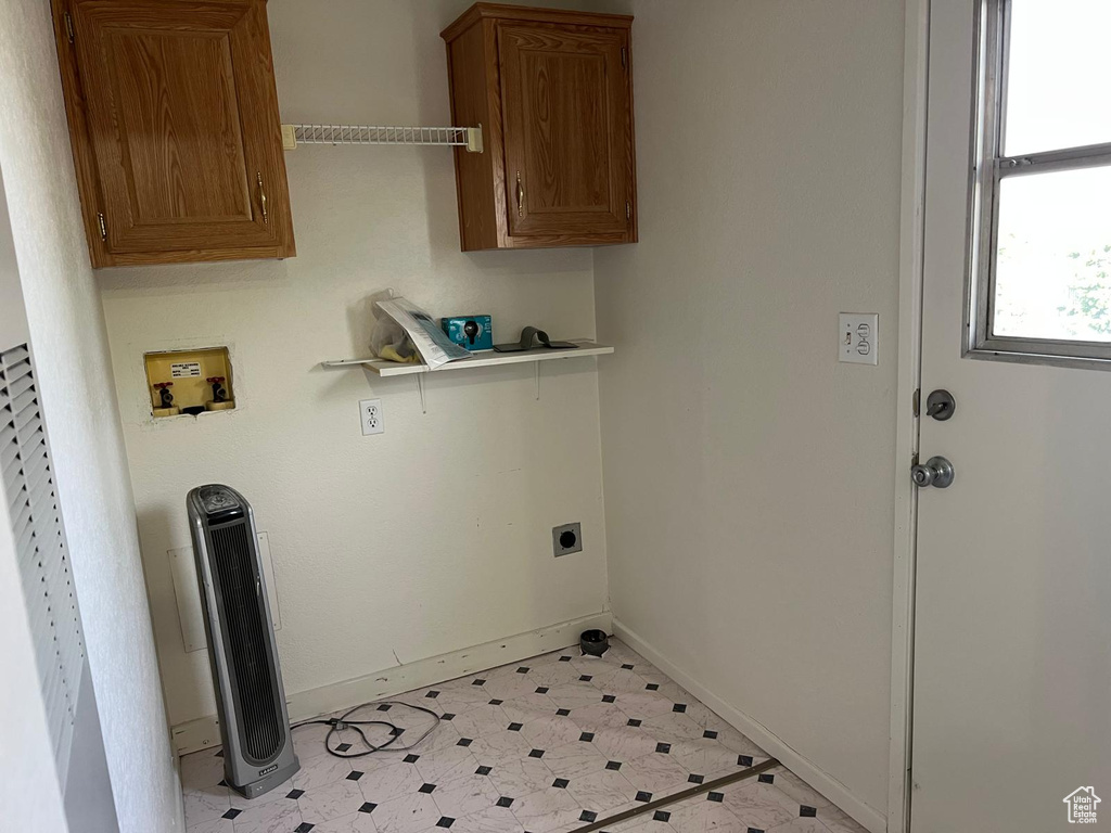 Laundry area with hookup for a washing machine, electric dryer hookup, baseboards, and cabinet space