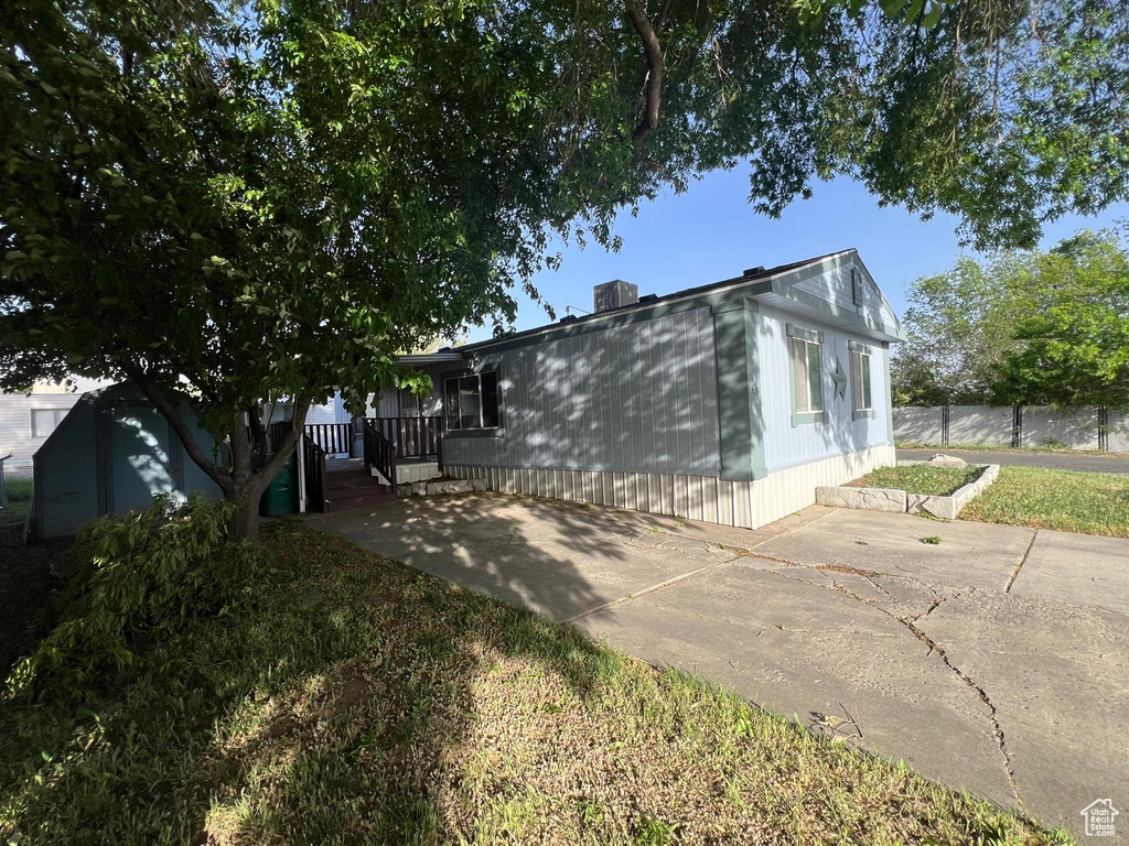 View of front of home with a chimney, fence, and a patio area