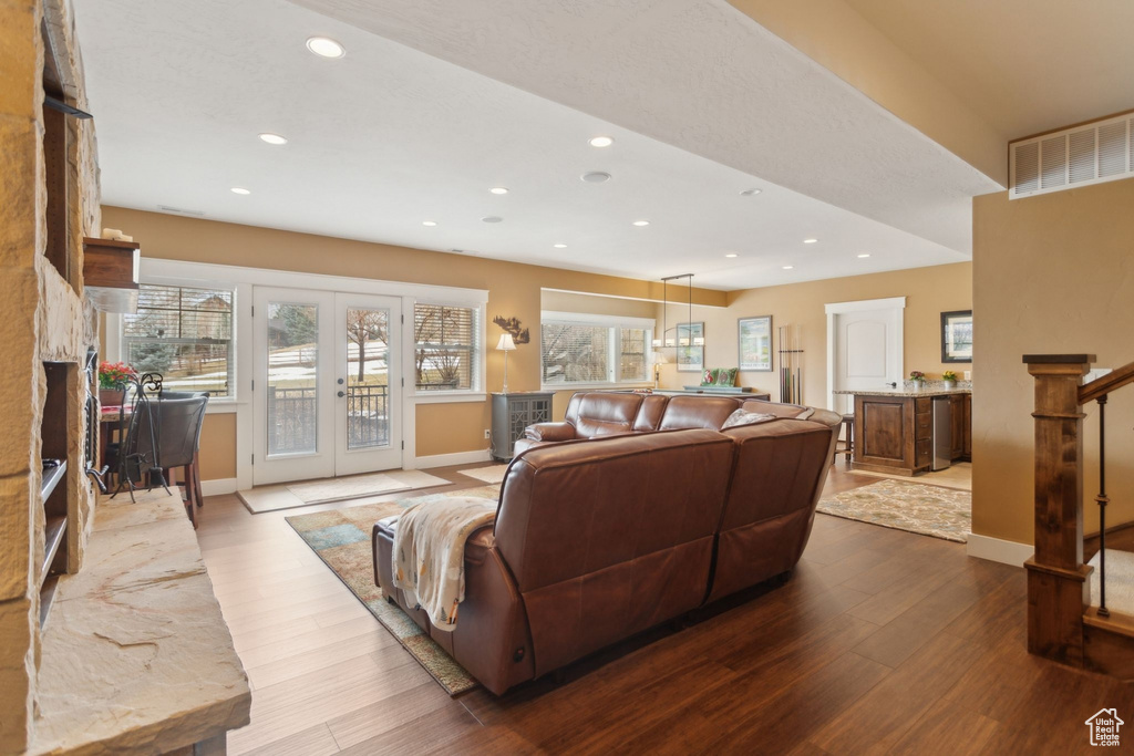 Living area with wood finished floors, baseboards, recessed lighting, and french doors
