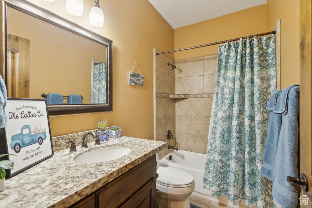 Full bathroom featuring shower / tub combo with curtain, vanity, and toilet