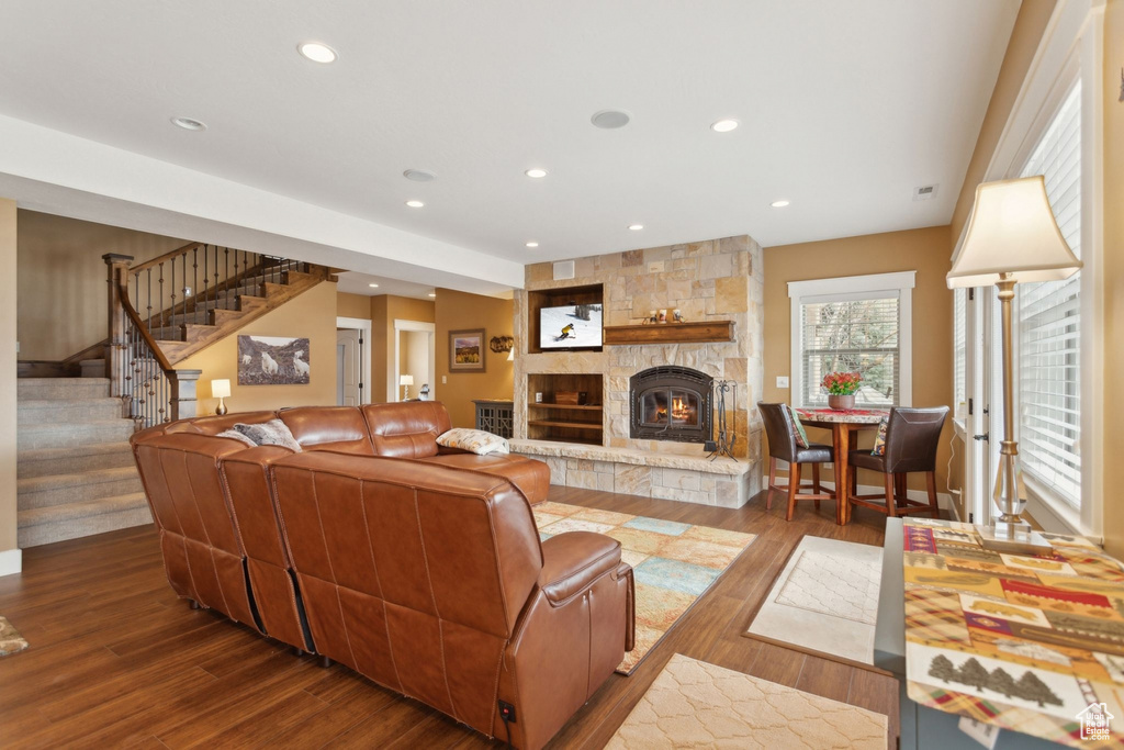 Living area featuring a fireplace, stairway, wood finished floors, and recessed lighting