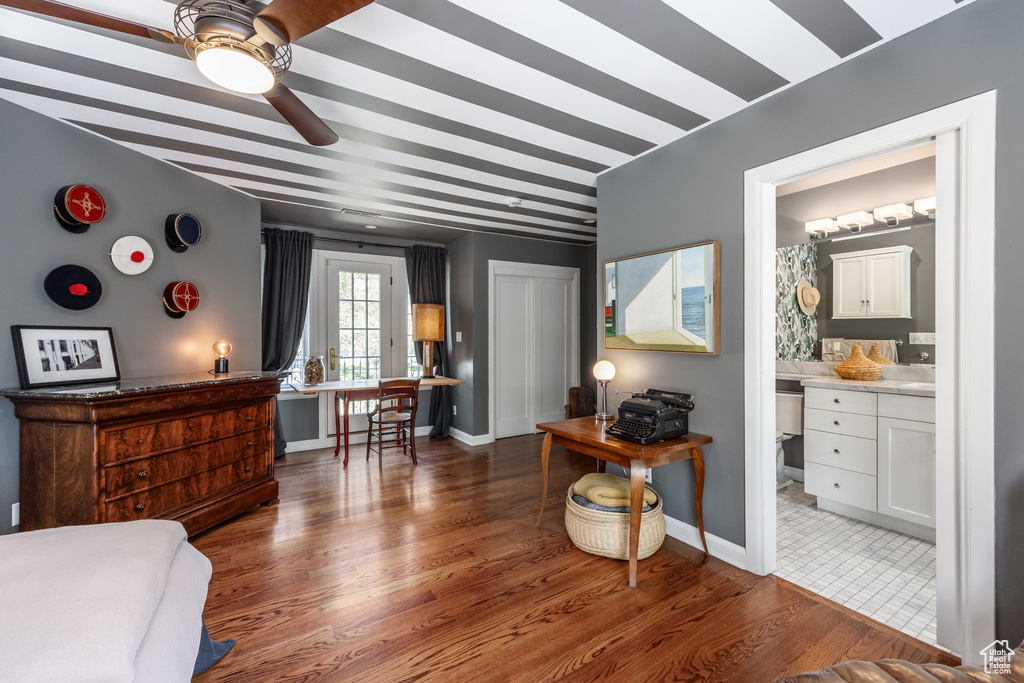 Bedroom featuring wood finished floors, baseboards, and ensuite bathroom