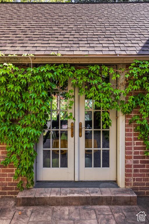 Doorway to property with brick siding and french doors