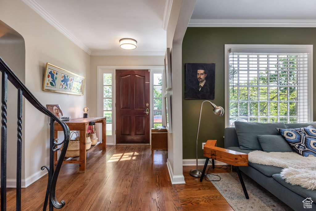 Foyer featuring ornamental molding, wood finished floors, baseboards, and stairs