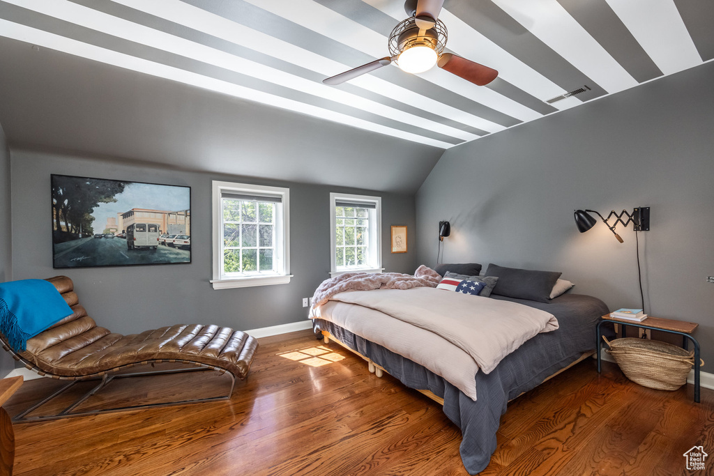 Bedroom with lofted ceiling, wood finished floors, baseboards, and a ceiling fan