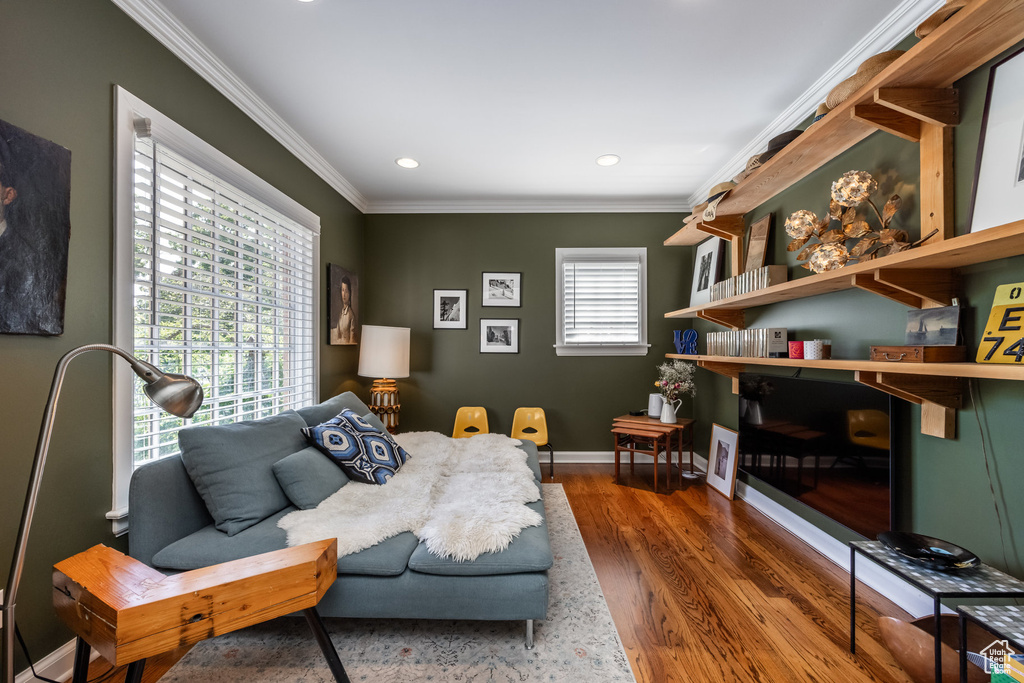 Living area with ornamental molding, wood finished floors, recessed lighting, and baseboards