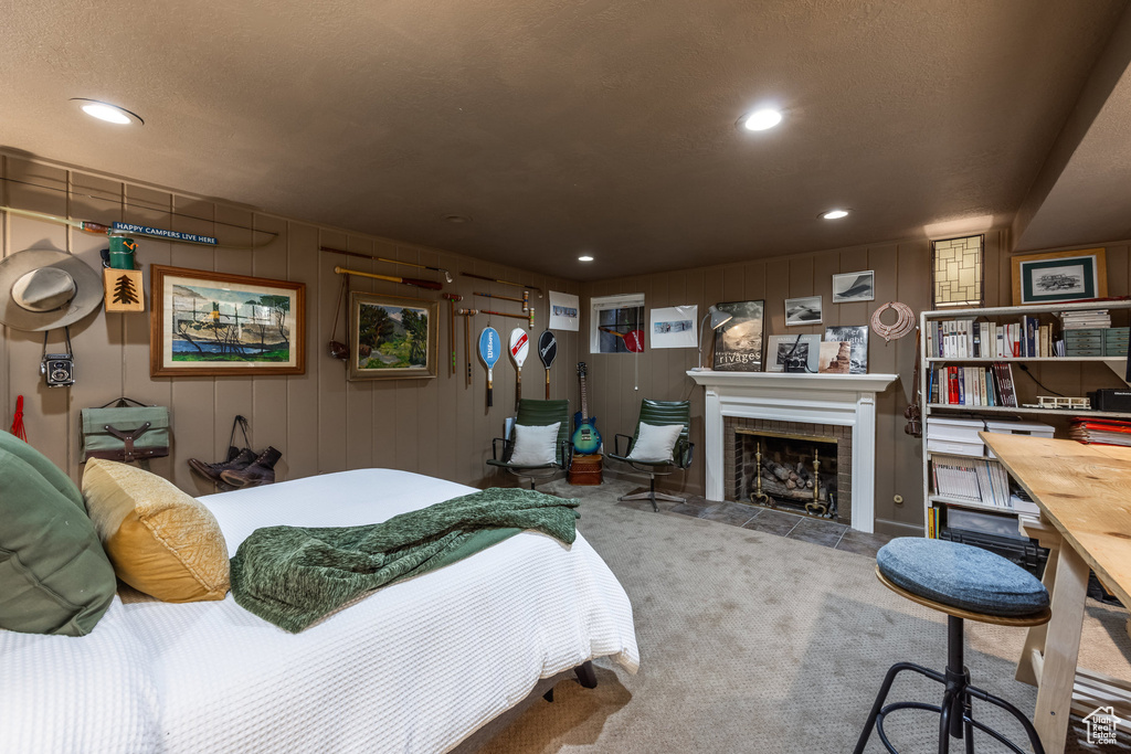 Carpeted bedroom with a tiled fireplace and recessed lighting