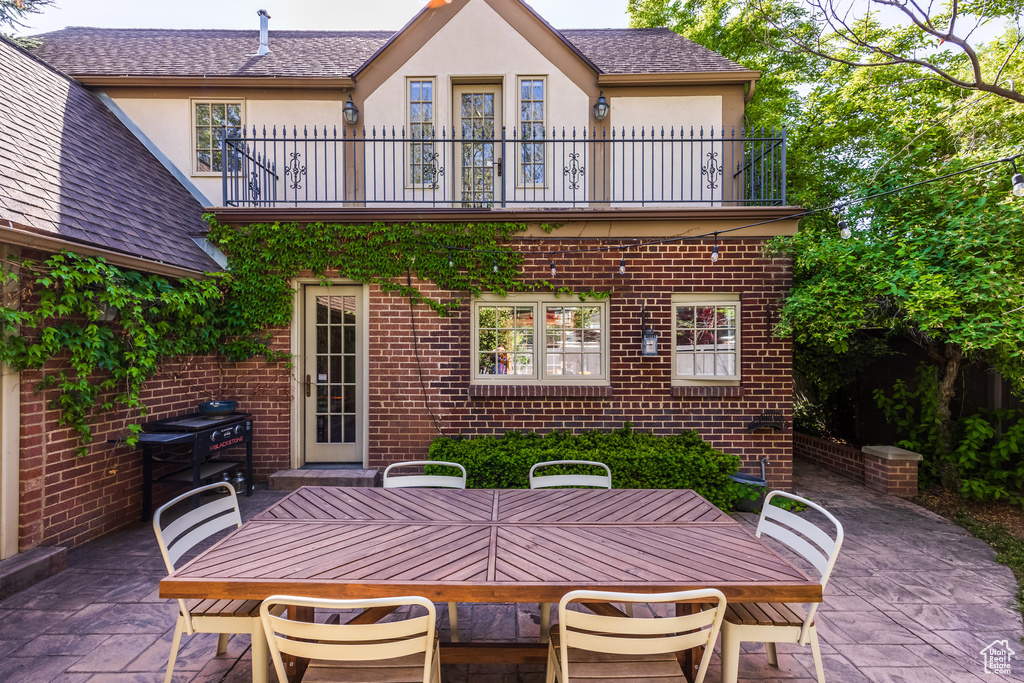 View of patio featuring a balcony and outdoor dining area