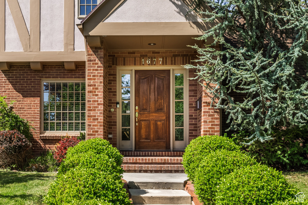 Property entrance featuring brick siding and stucco siding
