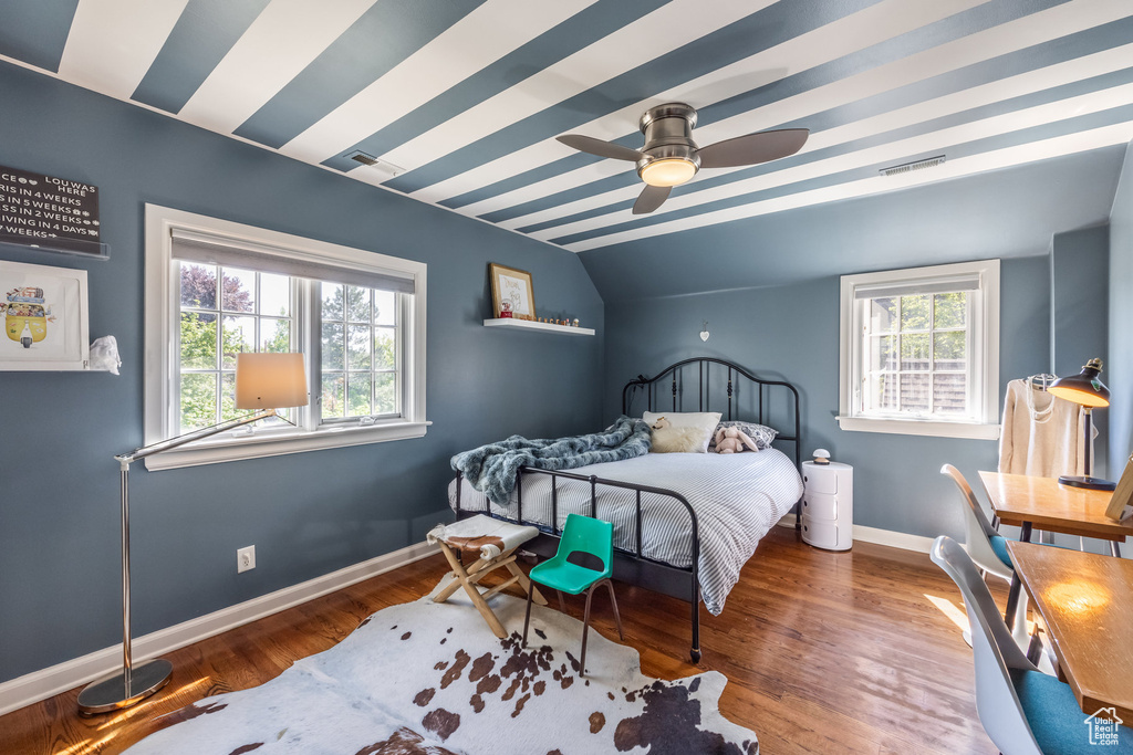 Bedroom featuring vaulted ceiling, baseboards, and wood finished floors