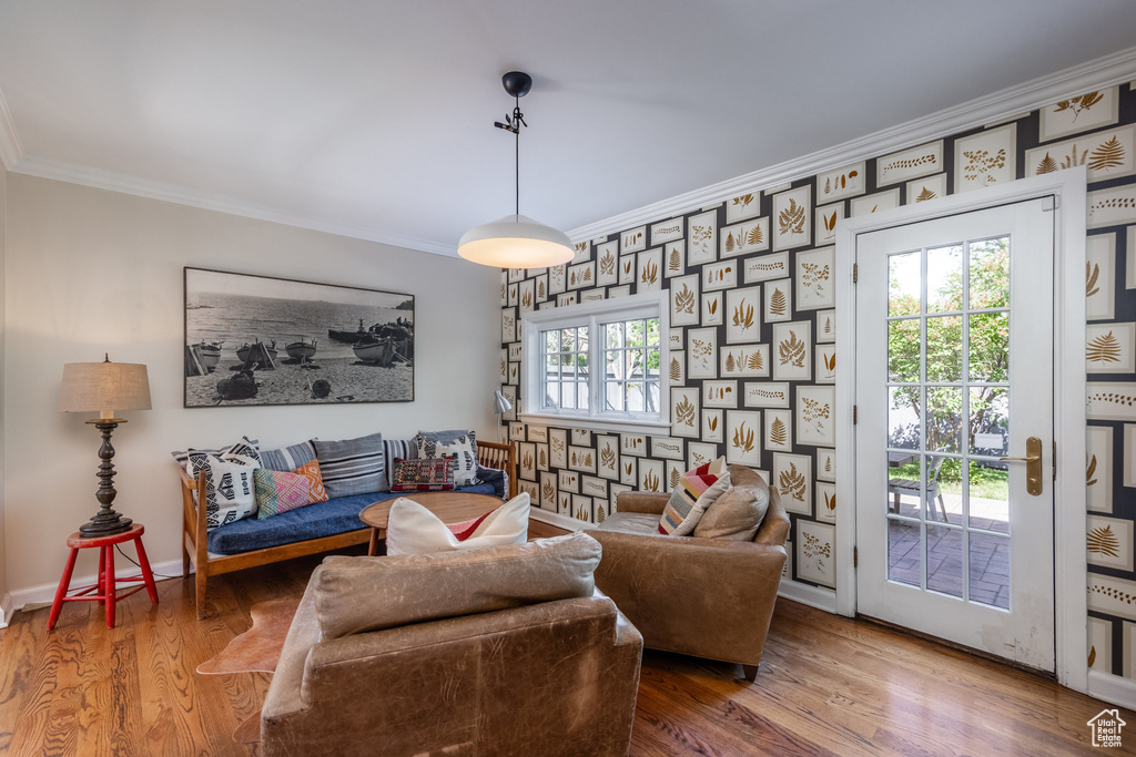 Living area with ornamental molding, wood finished floors, and baseboards