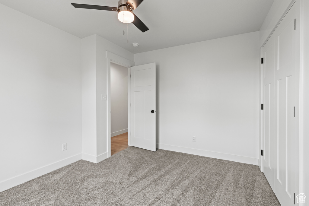 Unfurnished bedroom featuring carpet, baseboards, and a ceiling fan