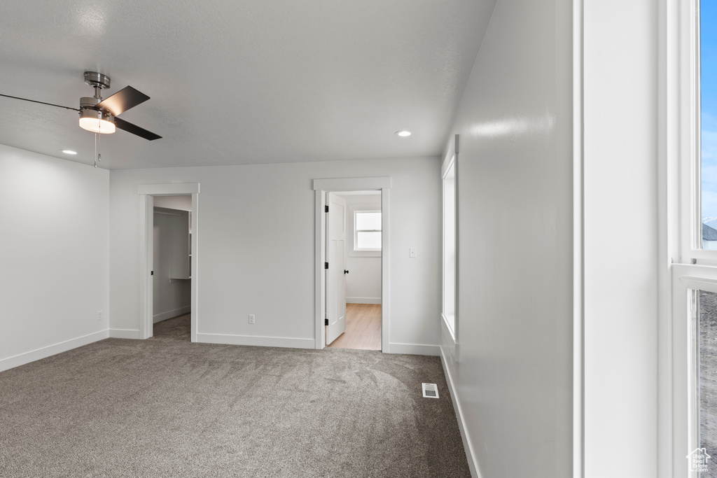 Unfurnished bedroom featuring baseboards, carpet, recessed lighting, a spacious closet, and ceiling fan
