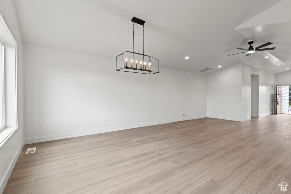 Unfurnished room featuring light wood-style floors, lofted ceiling, recessed lighting, baseboards, and a ceiling fan