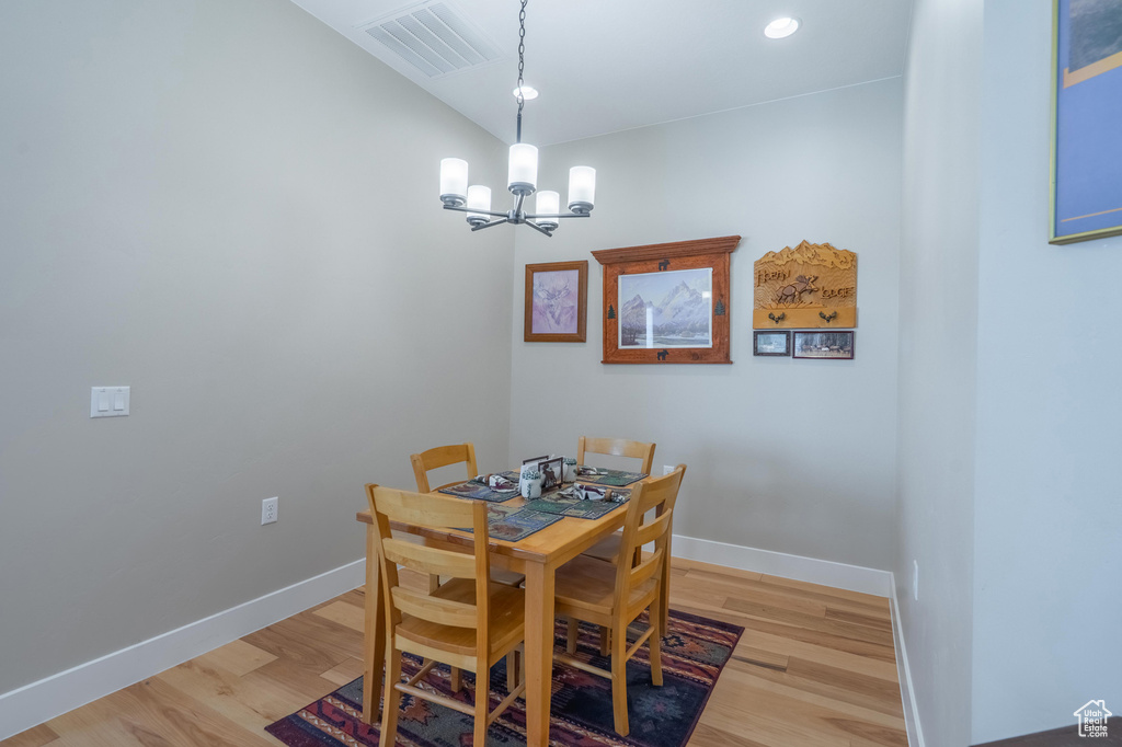 Dining room with a chandelier, light wood-style floors, baseboards, and recessed lighting
