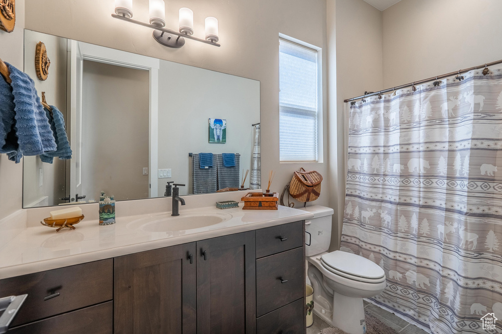 Full bath featuring vanity, toilet, and curtained shower
