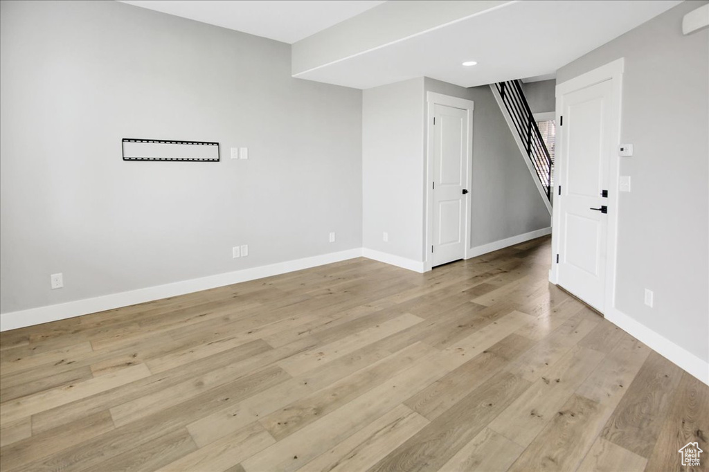 Below grade area featuring baseboards, stairway, light wood-style floors, and recessed lighting