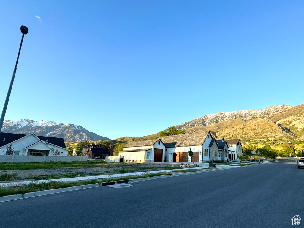 View of asphalt street with a mountain view, sidewalks, street lights, and a residential view