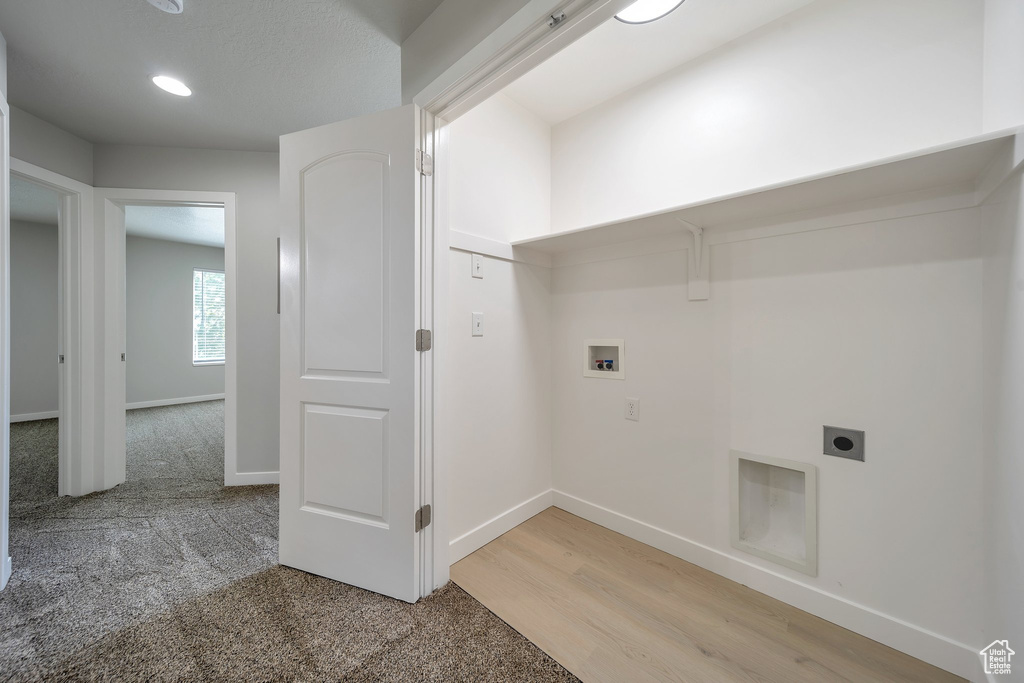 Clothes washing area with hookup for an electric dryer, washer hookup, baseboards, light wood-type flooring, and recessed lighting