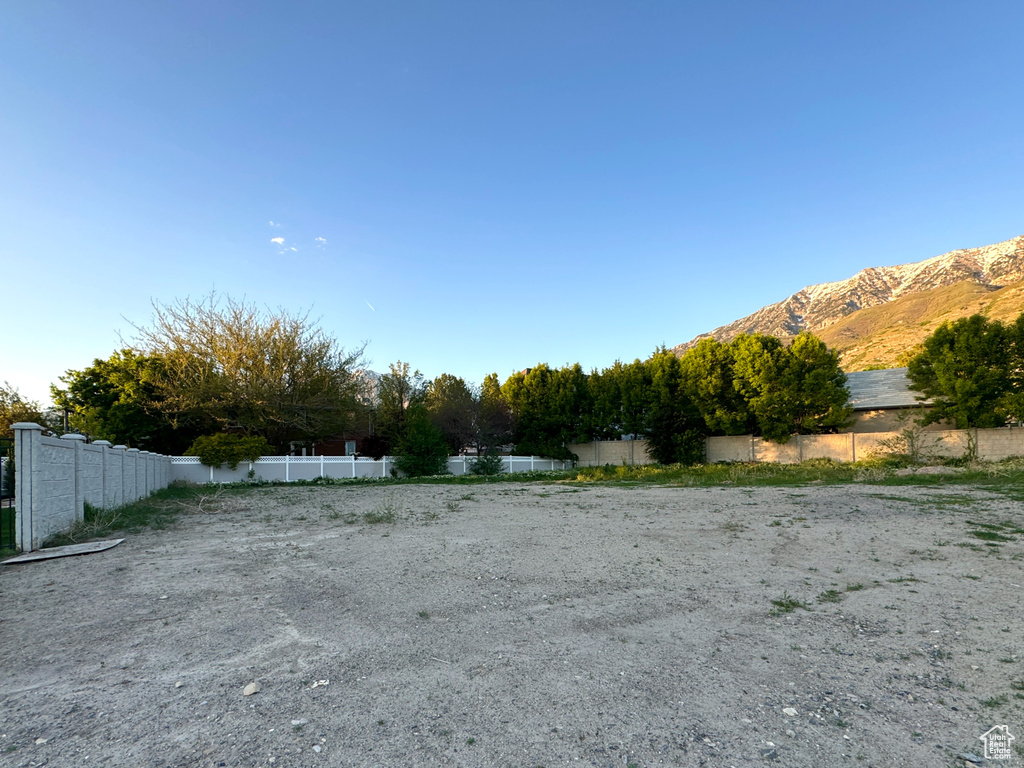 View of yard featuring fence and a mountain view