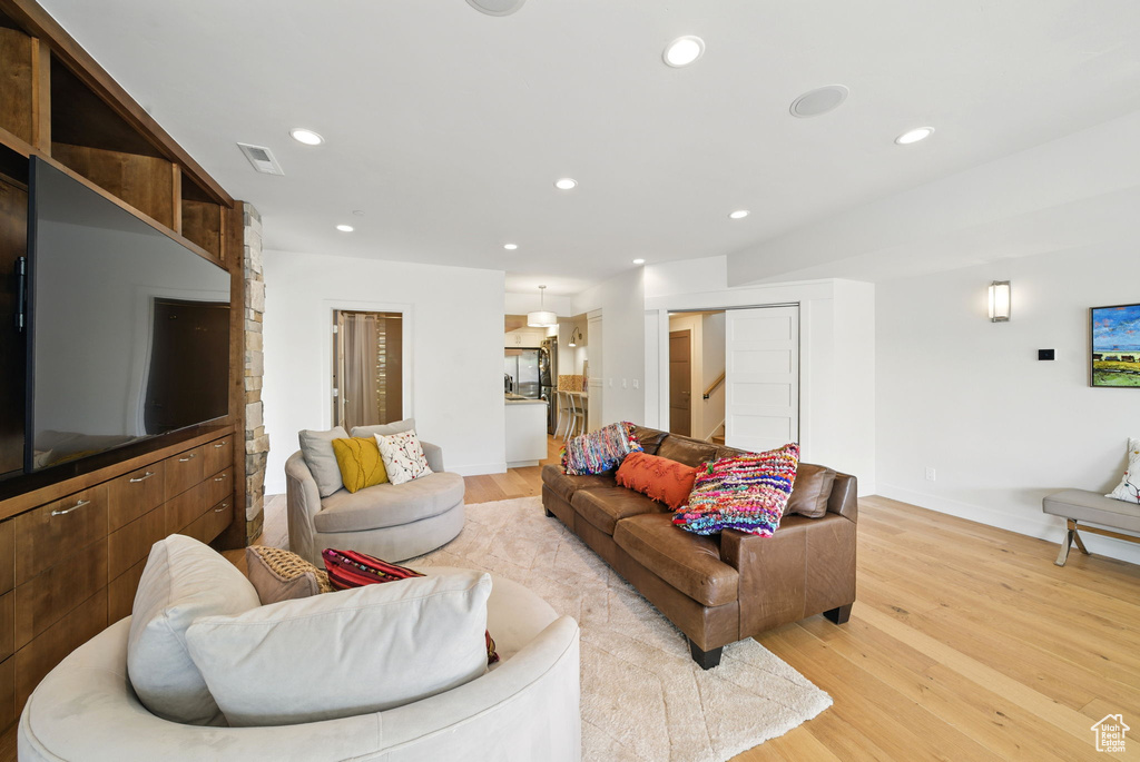 Living room with light wood-style flooring, baseboards, and recessed lighting