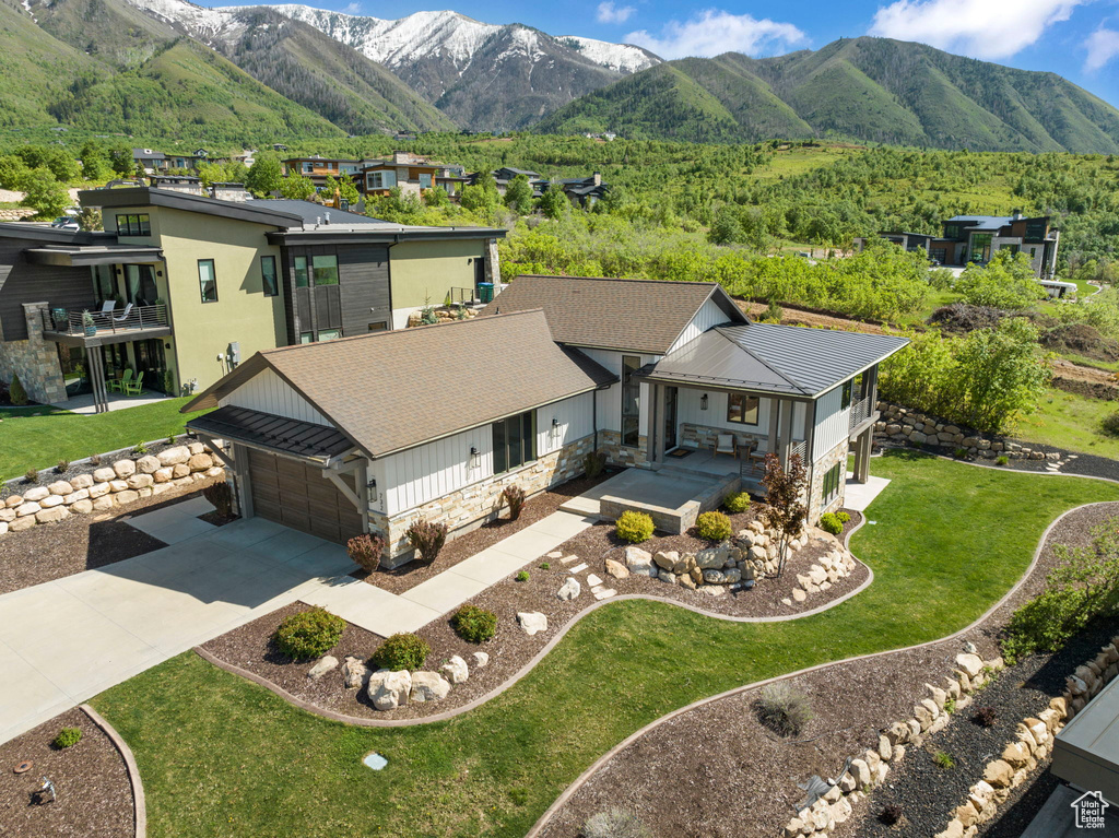Aerial view of property and surrounding area featuring a mountainous background