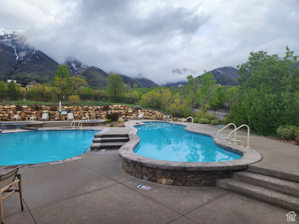 Community pool with a mountain view and a patio area
