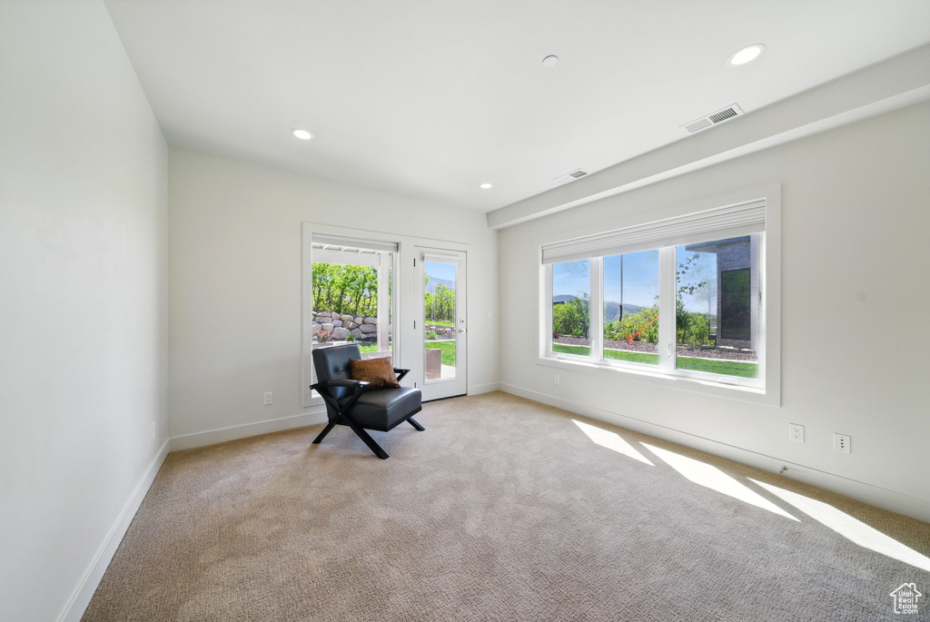 Sitting room with light colored carpet, baseboards, and recessed lighting